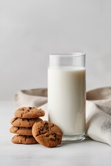 Chocolate chip cookies with glass of milk on neutral background