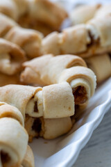 Close-Up of U-Shaped Apple Cookies on a Rectangular Plate on a White Wooden Surface