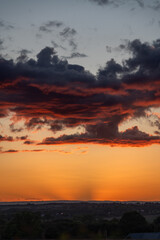 Unusual shaped clouds with a red tinge and an orange sky.