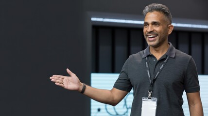 Smiling Middle-Aged Conference Keynote Speaker, Dark Polo, Open Gesture, Left Copy Space