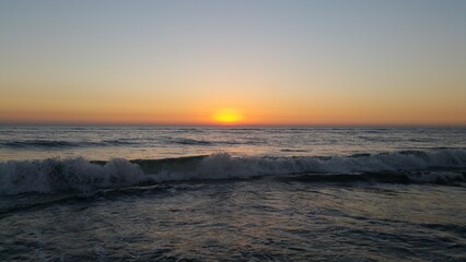 Stunning sunset over the ocean, capturing the golden hour, creating a serene coastal scene