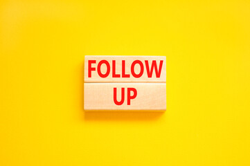 Follow up symbol. Concept word Follow up on beautiful wooden blocks. Beautiful yellow paper background. Business follow up concept. Copy space.