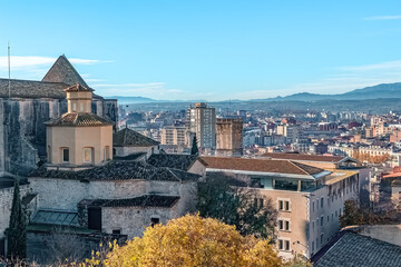 Panoramic cityscape of Girona, Spain, showcasing ancient architecture blending with modern urban...