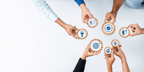 This image captures hands holding gears with icons, symbolizing teamwork and collaboration in a...