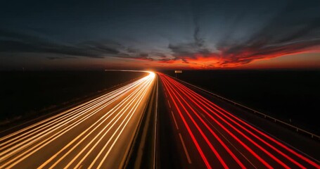 Highway at dusk with vibrant sunset and car light trails