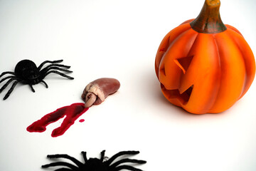 Halloween scene with carved pumpkin, black spiders, and organ with blood stains on white...