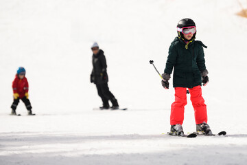 Children learning to ski on snowy slope