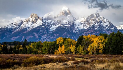 Fototapeta premium Snowy mountain range with autumnal forests
