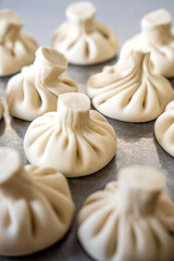 Uncooked khinkali dumplings on metal surface
