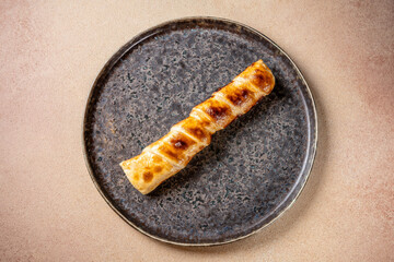 Woman holding baked pastry roll on plate