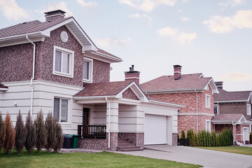Modern Suburban Brick Houses With Driveways and Well-Maintained Lawns Under Cloudy Sky