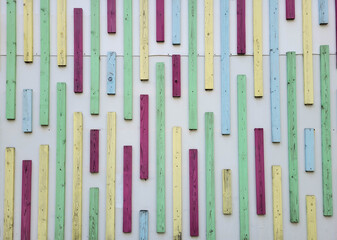 On a light-colored wall, a background with multicolored narrow bars