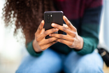 Close-up of African American woman’s hands using smartphone
