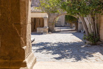 Obraz premium Historical buildings with arches in Greece. Old stone architecture at Filerimos Monastery on Rhodes Island Greece