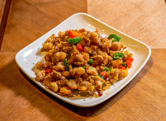 Crispy Salt and Pepper Chicken Cartilage with Chili on White Plate on Wood Table side view of Asian Snack Food