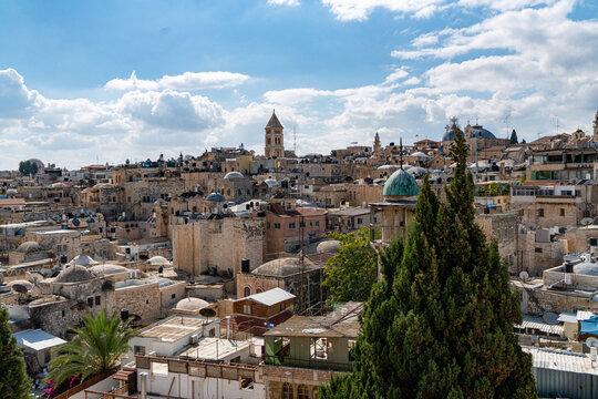 Jerusalem, Israel - 02 November 2019: View of the ancient city's rooftops under a bright sky, where stone buildings meet the sky, punctuated by domes and towers.