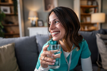 Young smiling nurse hydrating and relaxing at home