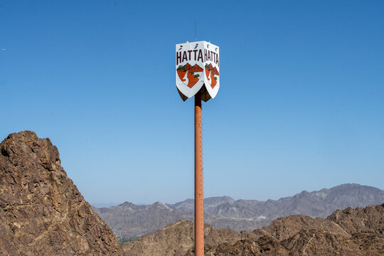 A sign marking the town of Hatta, a popular UAE destination for camping and recreational activity, known for its rugged Hajar Mountains landscape.
