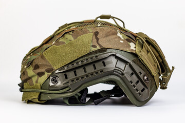 Vibrant front-view of a modern tactical combat helmet with a multicam cover, prominently showing...