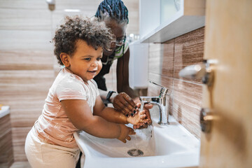 Joyful child learns handwashing in a cozy bathroom setting
