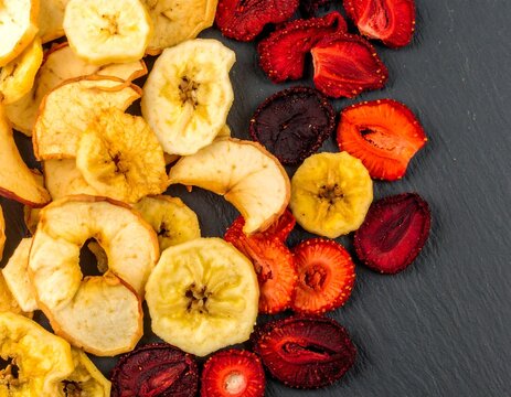 Assorted dried fruit slices on dark surface