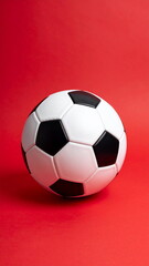 Classic black and white soccer ball on red background