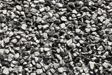 Stone gravel texture background. Natural crushed rock surface for construction material and road pavement. Rough aggregate pattern with small stones. Building industry detail concept.