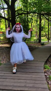A girl in a white dress and a veil, the image of a scary bride, a zombie, dancing coolly, on Halloween