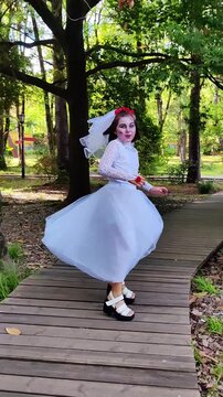 A girl in a white dress and a veil, the image of a scary bride, a zombie, dancing coolly, on Halloween