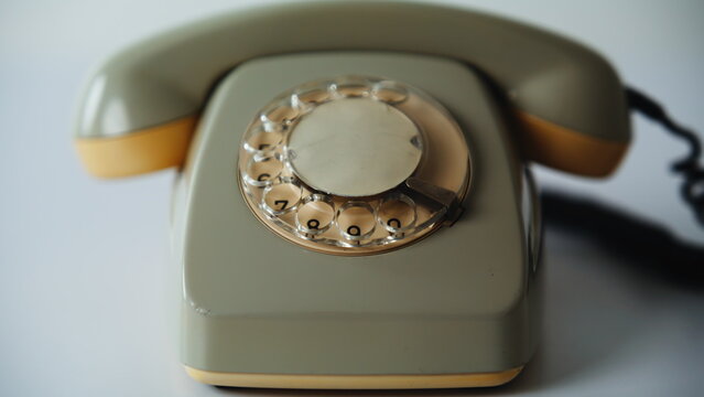 Retro stationary cell phone standing on white background closeup. Vintage rotary