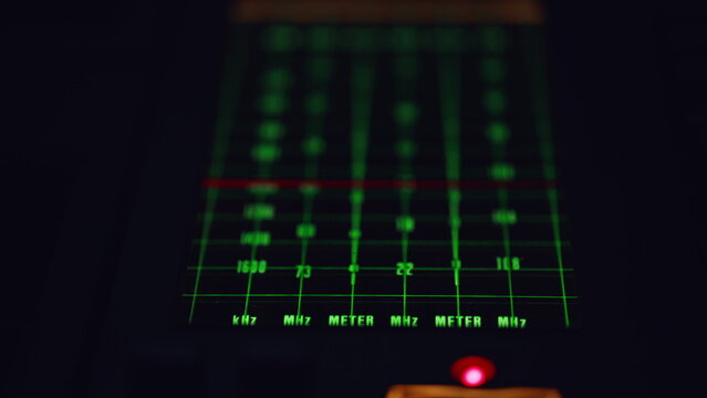 Closeup frequency display glowing green in silent studio atmosphere. Radio tuner - Powered by Adobe