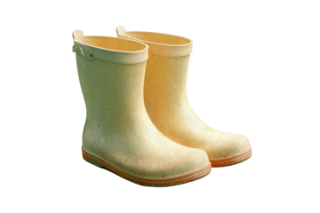 Yellow rubber boots with textured surface on black background, cut out
