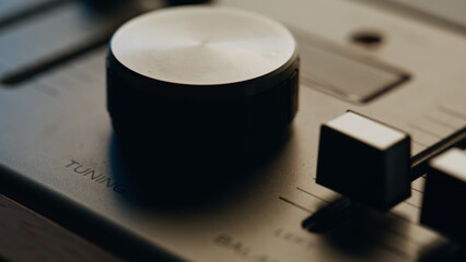 Closeup tuning knob vintage stereo in quiet studio. Macro view manual equipment 