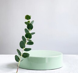 Green podium with eucalyptus branch on the white background