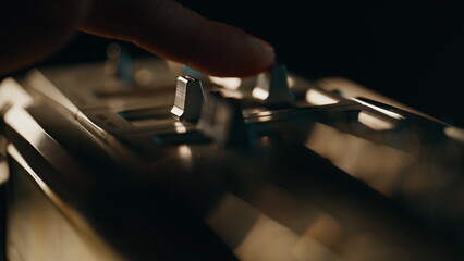 Finger pushing switch retro music player in dark apartment closeup. Man turning