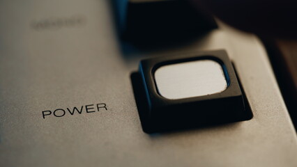 Finger turning off power button on retro device closeup. Man pushing knob