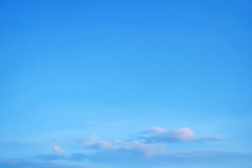 Light blue sky with soft clouds during a serene afternoon, creating a peaceful atmosphere over a scenic landscape