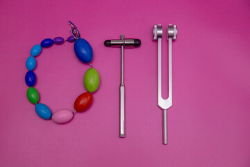 two tuning forks on pink Background and orchidometer, Space for Text, Space for Logo, medical instrument, medical equipment,