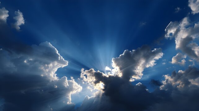 Dramatic deep blue sky filled with ethereal glowing clouds and shafts of divine light breaking through the atmospheric expanse creating a sense of wonder and spirituality above.