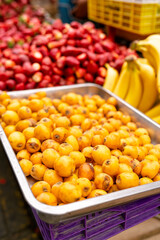 Loquats and other fresh fruits in a market stall