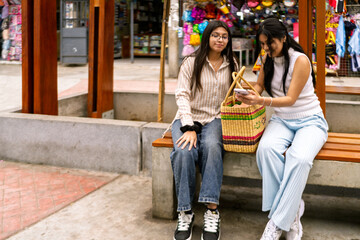 Two friends shopping enjoying mobile phone content