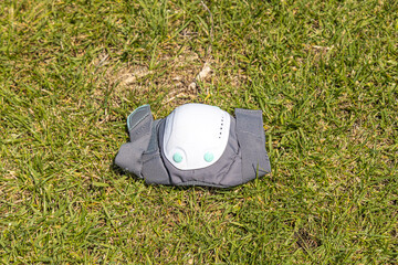 A gray elbow pad on the green grass background