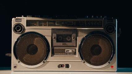 Fototapeta premium Closeup retro boombox standing on table in evening light. Old cassette player 