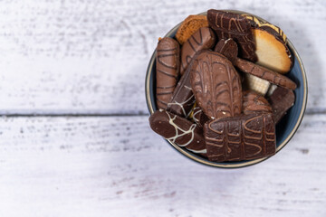 A bowl of cookies on a wooden background. Coffee cookies on a light wooden background