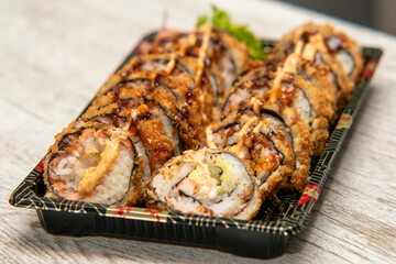 sushi on a plate,delicious rolls in a Japanese restaurant,Sushi and rolls, Japanese sea cuisine,Dragon Rolls at home,  Roll is another popular sushi roll serve,