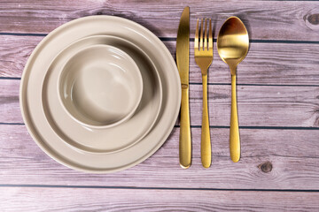 Empty plates, knife and fork over wooden table background. View from top with copy space.lose weight illustrated with an empty plate.