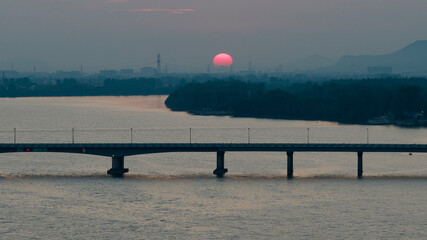 Scenic View of Lake and Bridge Under Red Sunset Sky in Guizhou China