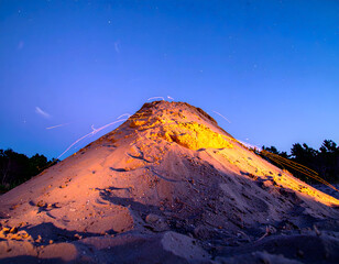 Vibrant Sand Mountain Under Night Sky with Star Trail Effects