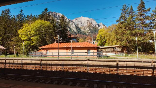 Busteni Train Station, Busteni, Transylvania, Romania, featuring traditional architecture, platform canopies and a landmark clock set against mountain slopes