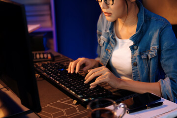 Thinking young beautiful Asian creative woman analyzing profit of sales target report comparing on email sending business market report, writing on notebook for memo at neon light at night. Stratagem.